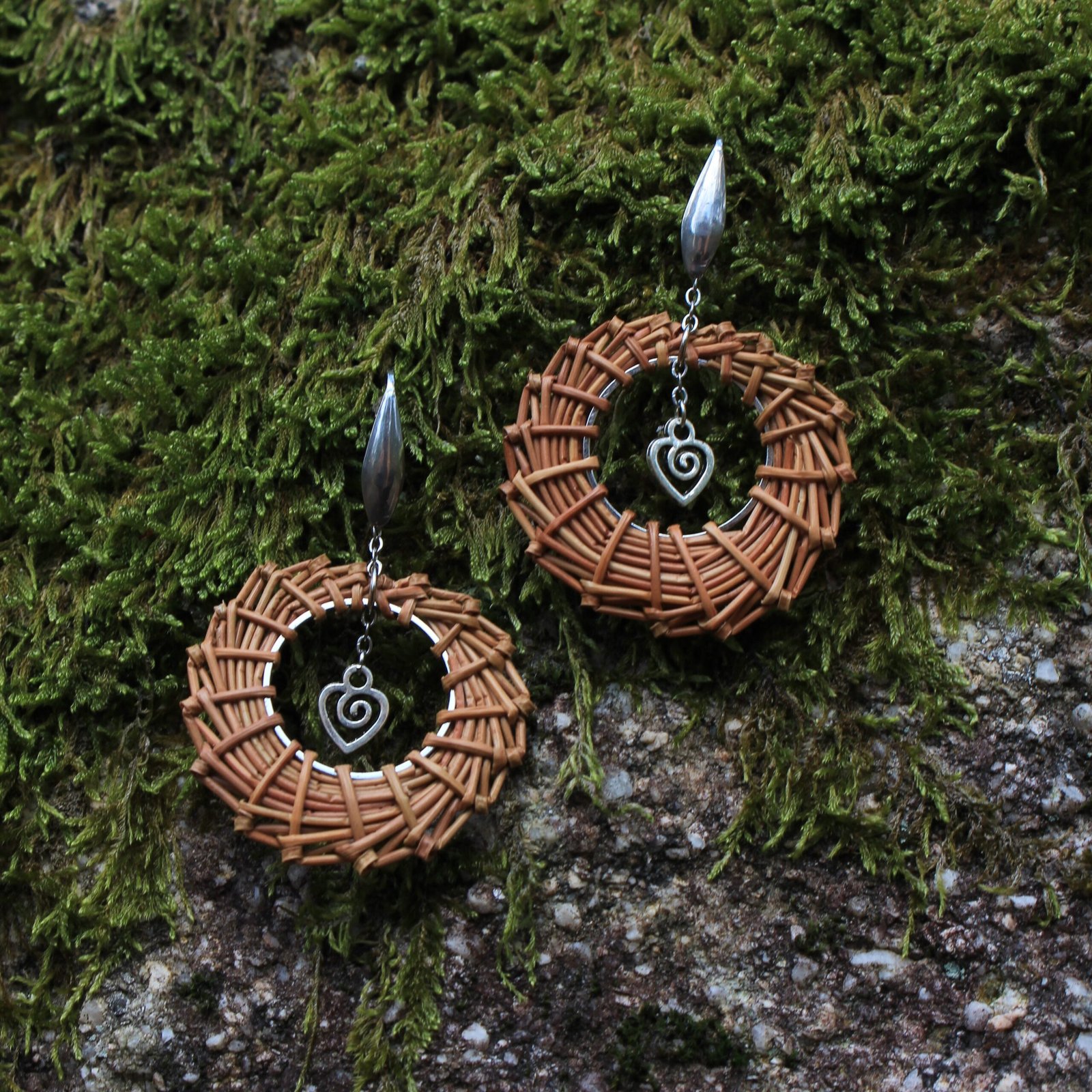 Boucles d’oreilles cœur inox Boucles d’oreilles cœur en acier inoxydable argenté et aiguilles de pin laricio tressées à la main, vue de face.
